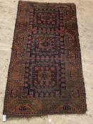 An antique bokhara rug, the dark red field with six gul motif and bordered. 93cm x 140cm.