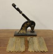 A 19th century black laquered and gilt painted stamp press, (H40cm) together with three pairs of