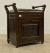 A late Victorian carved walnut piano stool, with turned handles above an upholstered seat opening to