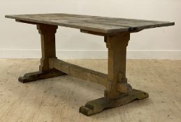 A pine refectory type dining table, 20th century, the rectangular top raised on shaped panel end