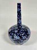 A Japanese style slim neck bulbous  blue and white vase decorated allover with cherry blossom design