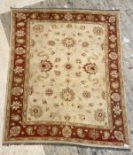 A Zielgler pattern flat weave rug, the beige field with lotus head design within a red border