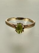 A 9ct gold oval cut peridot solitaire ring mounted in four claw setting S/T 2.3g