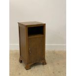 An early 20th century oak bedside cupboard, with open shelf above a single door enclosing a shelf,