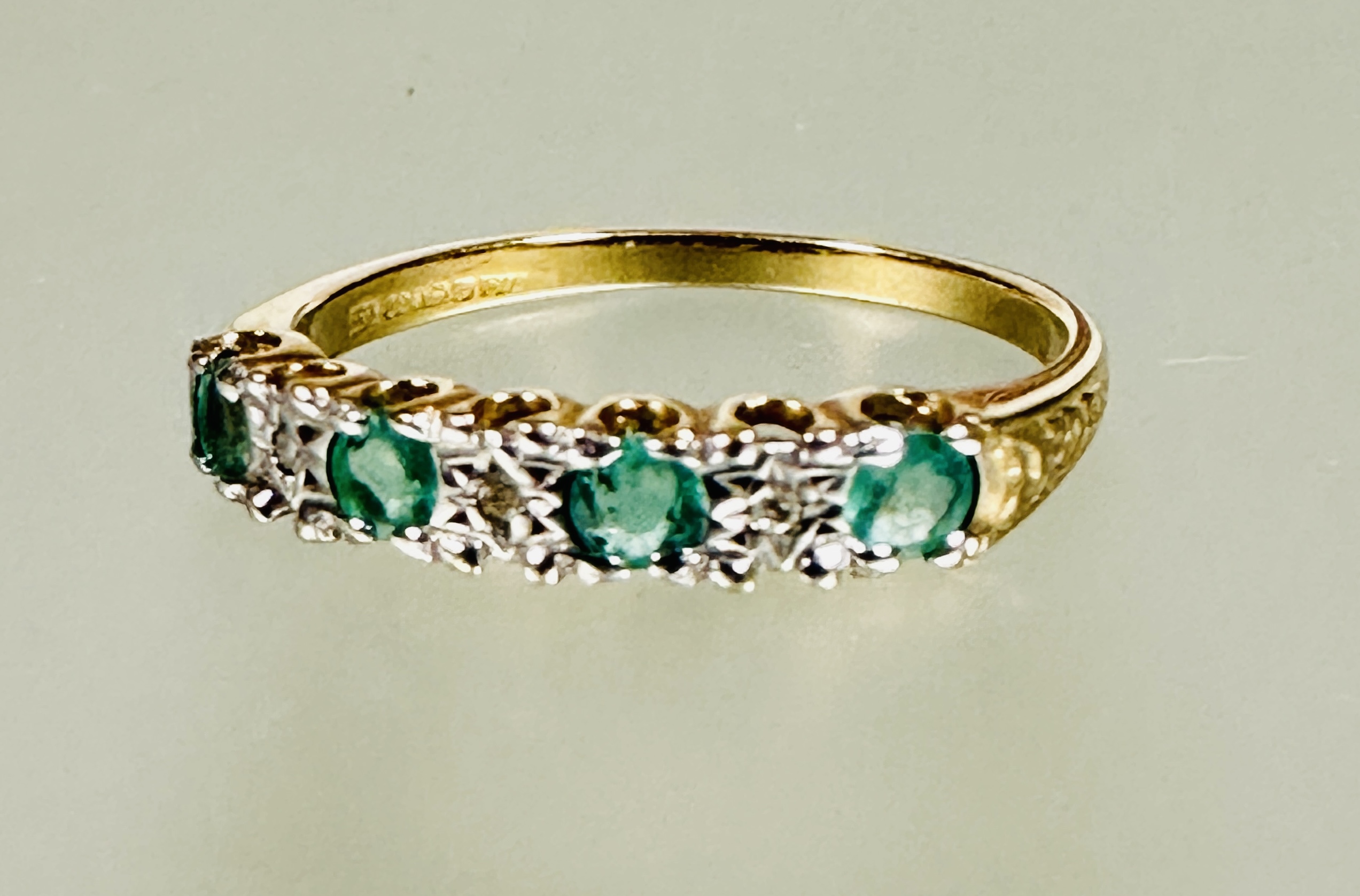 A 9ct gold four stone emerald and three stone diamond set ring the emeralds approximately 0.1ct N