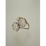 A 9ct fold cluster toi et moi style ring set seven round cut diamonds within a baguette set border
