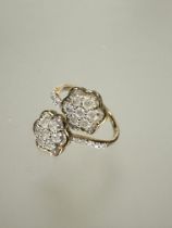 A 9ct fold cluster toi et moi style ring set seven round cut diamonds within a baguette set border