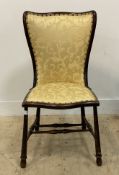 An Arts and Crafts period stained walnut occasional chair, upholstered in yellow damask. H93cm.