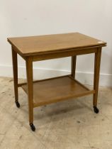 A mid century oak card table, having a fold over revolving top opening to a baize lined playing