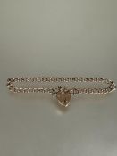 A 9ct gold curb link chain bracelet with 9ct gold heart shaped padlock and safety chain D x 9cm