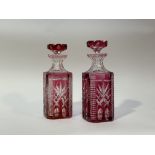 A pair of 19thc Bohemian Cranberry overlaid crystal decanters, both with original stoppers. (h-25.