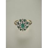 A 9ct gold emerald and cz cluster ring with oval central emerald and outer border of eight