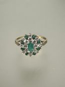 A 9ct gold emerald and cz cluster ring with oval central emerald and outer border of eight