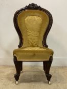 A Victorian strained walnut spoon back slipper chair, with floral carved crest above upholstered