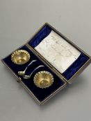 A pair of Victorian Birmingham cased silver gilt individual crimped edged salt sellers with spoons