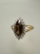 A 9ct gold dress ring set navette shaped cairngorm enclosed within a cz border S 3.57g