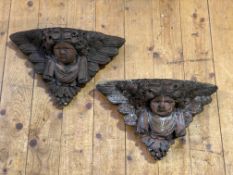 A pair of terracotta coloured reconstituted stone garden wall pocket planters modelled as cherubs.