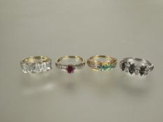 A group of four silver gem set rings to include a five stone cushion cut ring, a three stone green