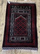 A hand knotted wool prayer rug, with mihrab to centre enclosed by a guarded border. 88cm x 154cm.