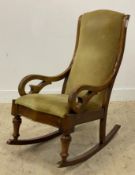 A late 19th / early 20th century mahogany rocking chair upholstered in yellow drylon, raised on