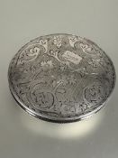 A 833 standard white metal circular compact with engraved scrolling leaf and floral design and