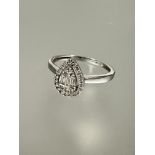 A 9ct white gold ring of heart shape, the center set three baguette cut diamonds and three diamond