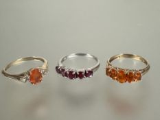 A 9ct gold graduated five amber coloured stone set ring P, a 9ct gold oval amber cut stone ring