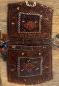 A hand knotted wool Baluchi saddle bag of typical design. 105cm x 58cm.