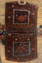 A hand knotted wool Baluchi saddle bag of typical design. 105cm x 58cm.