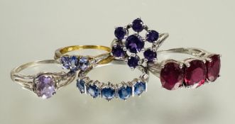 A group of five silver gem set rings including a amethyst colored cluster ring, a red three stone