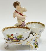 A Berlin porcelain double salt with cherub/putto figure, decorated in polychrome enamels with scenes