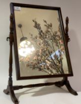 An early 20th century vanity mirror, the rectangular plate swivelling between ring turned