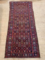 A Caucasian hand knotted rug, mid 20th century, the field of geometric design and bordered 290CM X
