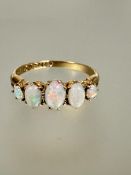 A 18ct gold graduated five stone fire opal cabouchon ring mounted in claw setting slight wear to