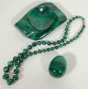 A group of malachite items comprising a beaded necklace, a carved pin dish and a turned egg (3)