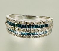 A 9ct white gold half eternity style ring twin channel set caliber green stones flanked enclosed