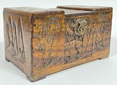 A miniature camphor wood chest with brass lock/mount and carved figural and nautical decoration (