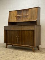 A mid century walnut side cabinet, the superstructure with sliding doors enclosing adjustable