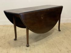 A George III mahogany drop leaf table, the oval top raised on turned supports with pad feet.