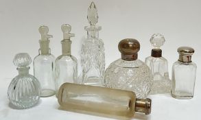 A group of glass scent bottles comprising four clear glass bottles of various forms and decorations,