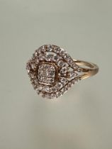 A 9ct rose gold ring, the center with nine claw set diamonds within two radiating rows of diamond