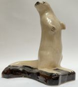 A Rye pottery standing otter figure on shaped base (marked verso)