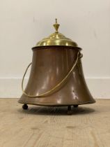 A 19th century copper and brass lidded bucket, with swing handle, urn finial and on three ball