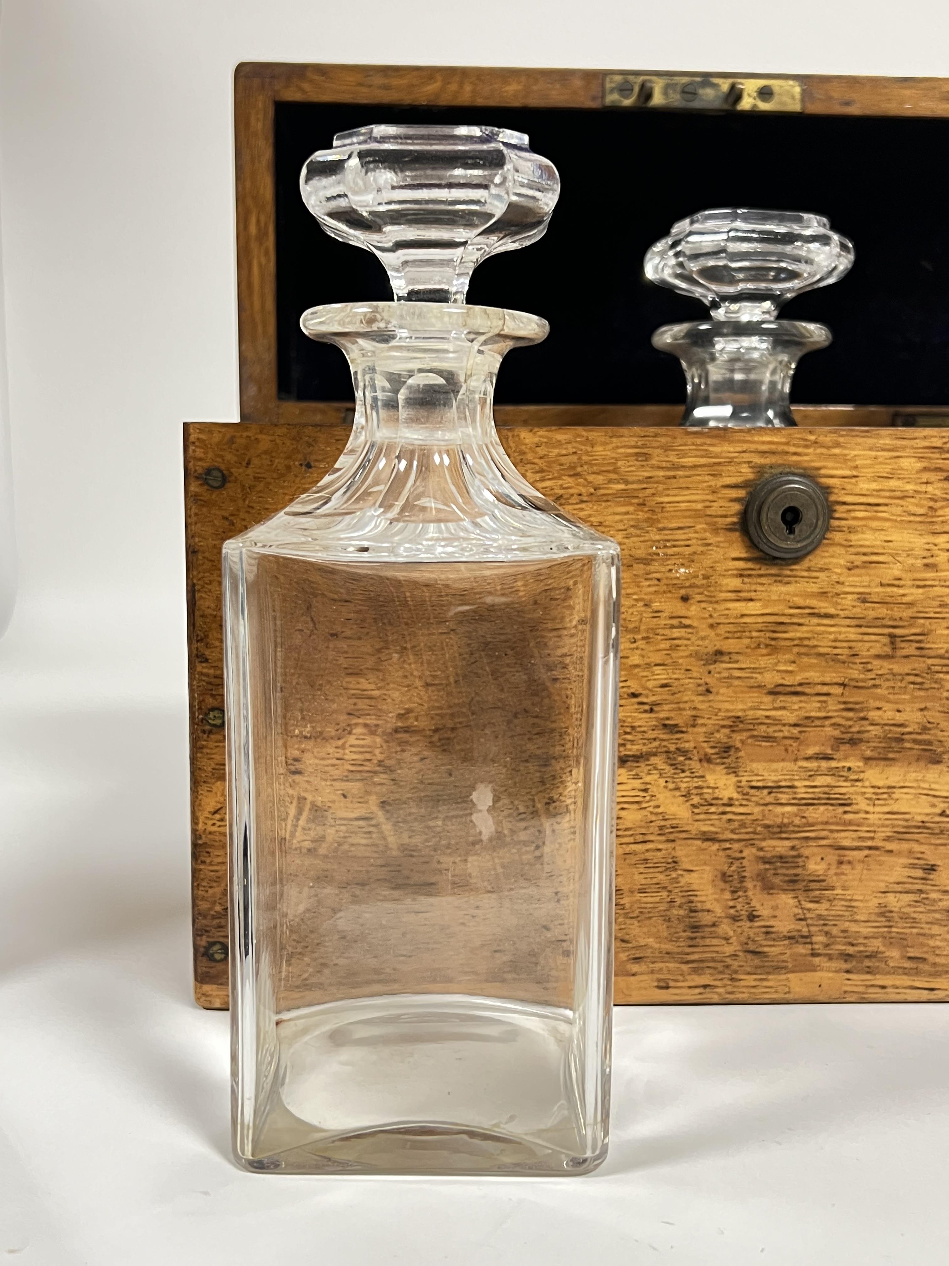 An early twentieth century leather lined oak spirits container/tantalus with three clear glass - Image 4 of 4