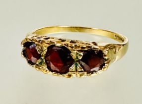 A 9ct gold graduated three stone circular garnet set ring center stone approximately 0.33ct N 2.06g