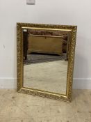 A traditional gilt composition wall hanging mirror with floral moulded frame. 67cm x 82cm.