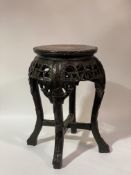 A late Qing dynasty Chinese rosewood jardinière stand, the circular top inset with rouge marble