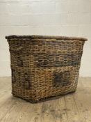 An oversized 19th century wicker laundry basket, the hinged lid opening to a plain interior and