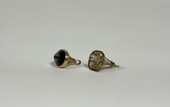 Two yellow-metal mounted fobs, the first with large oval amethyst glass matrix in a mount with