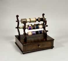 An early Victorian mahogany bobbin stand, of twin scroll-carved pairs of uprights, each fitted